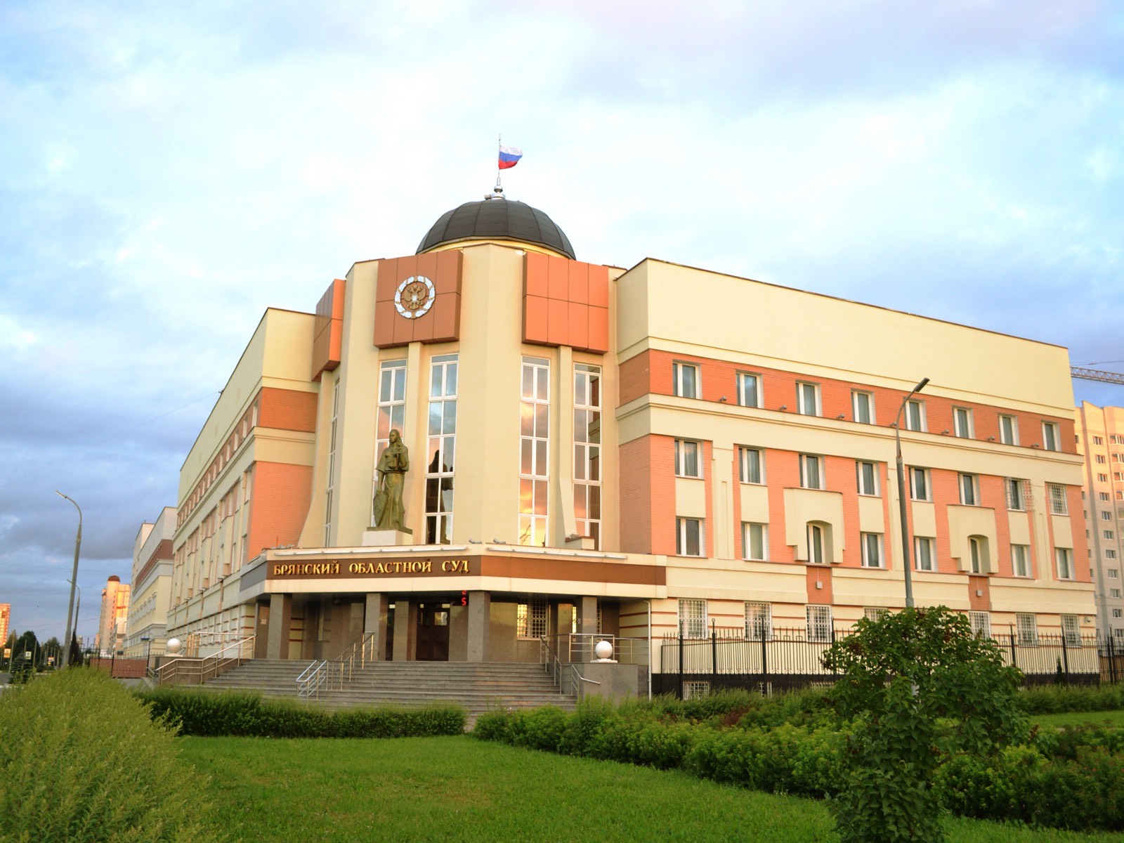Здание Брянского областного суда: купол с флагом над входом, статуя Фемиды у колонны и вывеска над крыльцом