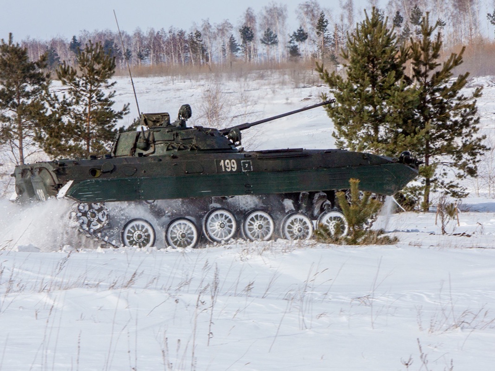 БМП-2 идёт по заснеженному полю на полигоне, из-под гусениц взлетает снежная пыль