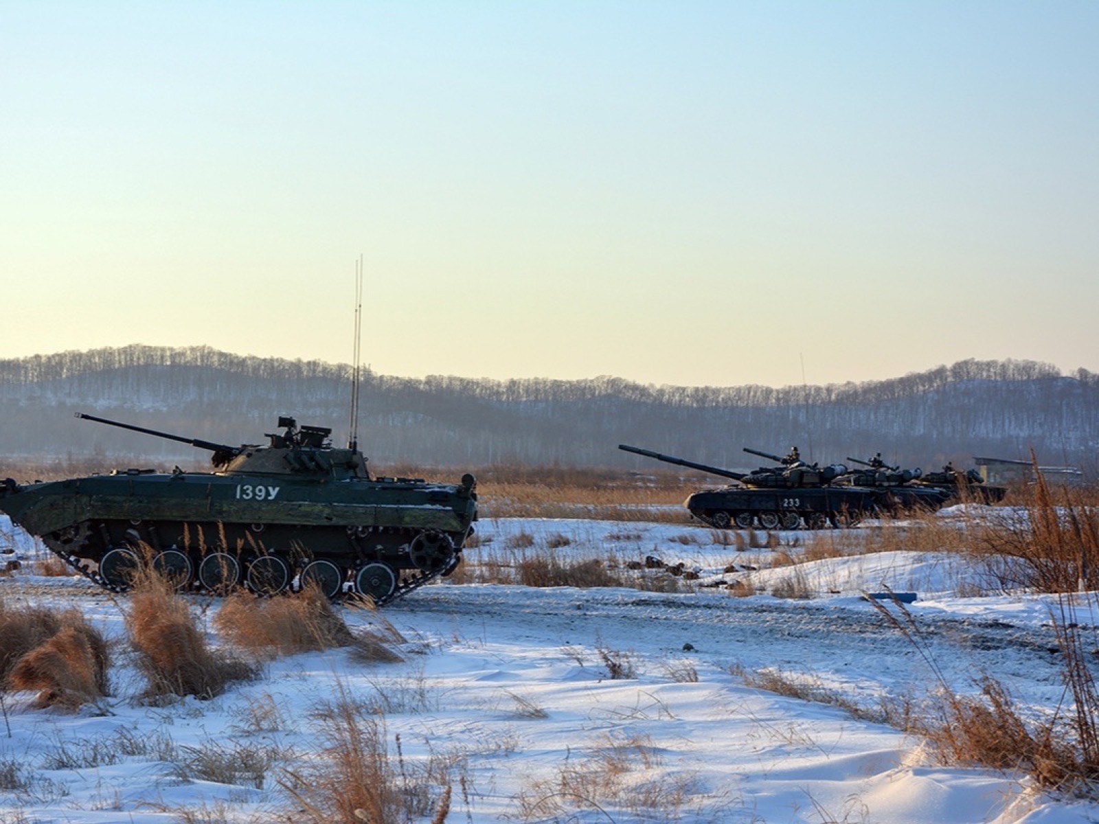 БМП-3 и танки Т-80БВ на заснеженном поле у подножия сопок на закате